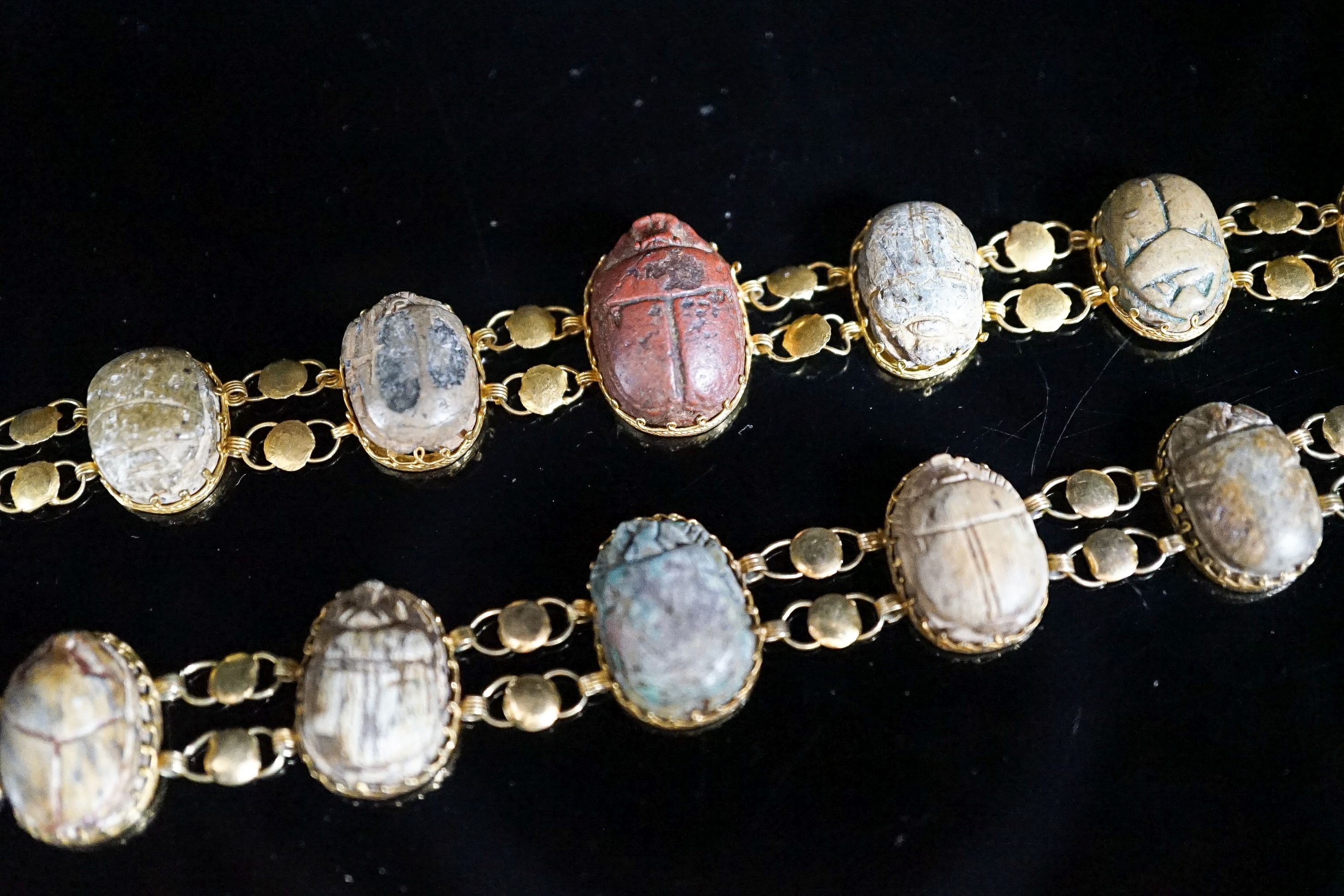 Two similar early 20th century yellow metal mounted scarab bracelets (a.f.), 18.5cm et infra, gross weight 38.1 grams.